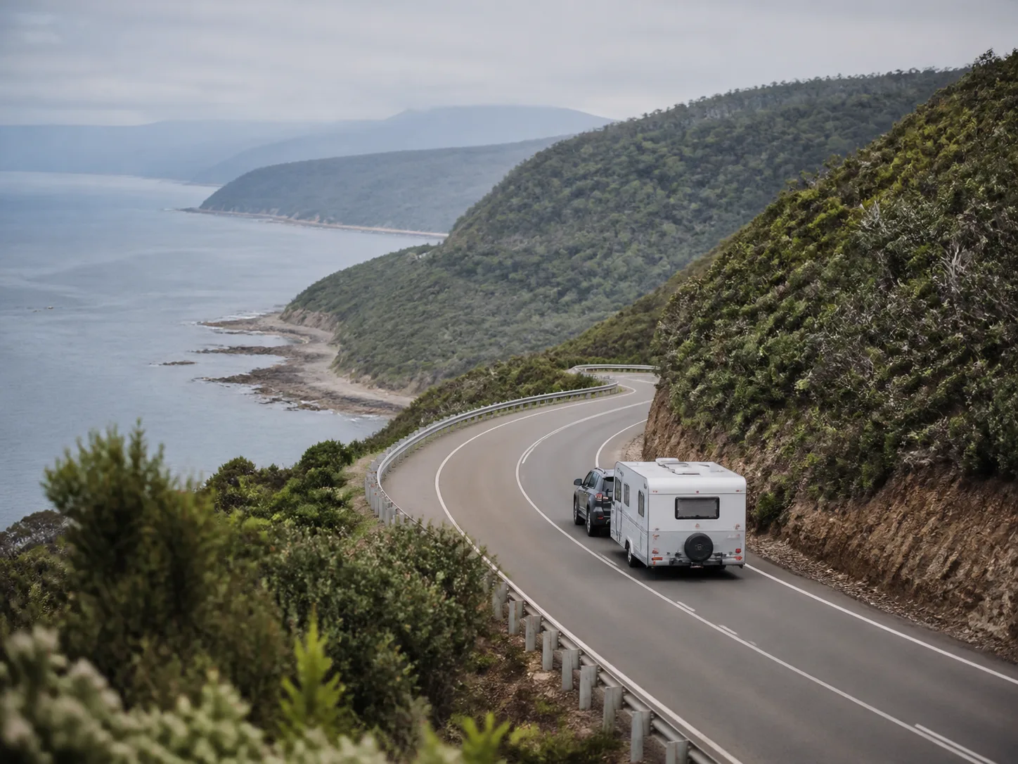 Caravan travelling a green coastal road in Tasmania